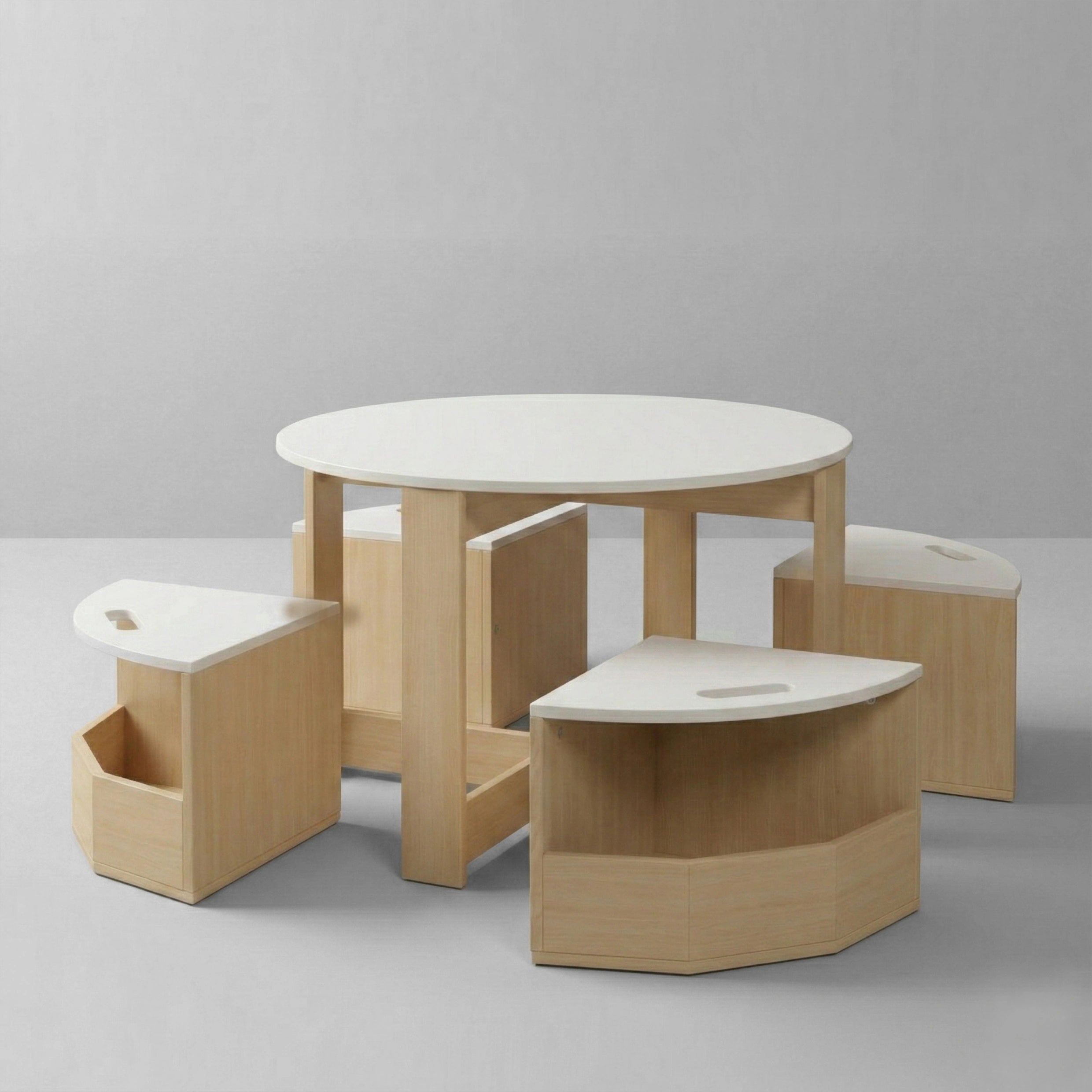 Studio shot of a 5-piece children's furniture set featuring a round table with a white top and four matching wooden chairs slightly pulled out, revealing their storage compartments.