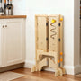 Hicooo wooden learning tower folded flat and stored compactly against a kitchen wall, demonstrating its space-saving design for small homes