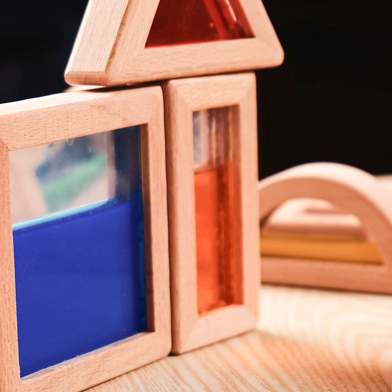 Close-up of stacked square and triangular wooden blocks filled with colorful sensory sand and liquids.