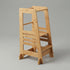 A side-angle view of the Hicooo natural bamboo kitchen helper tower on a light grey background, highlighting its stable A-frame design, wooden safety dowels, and multi-level step structure.