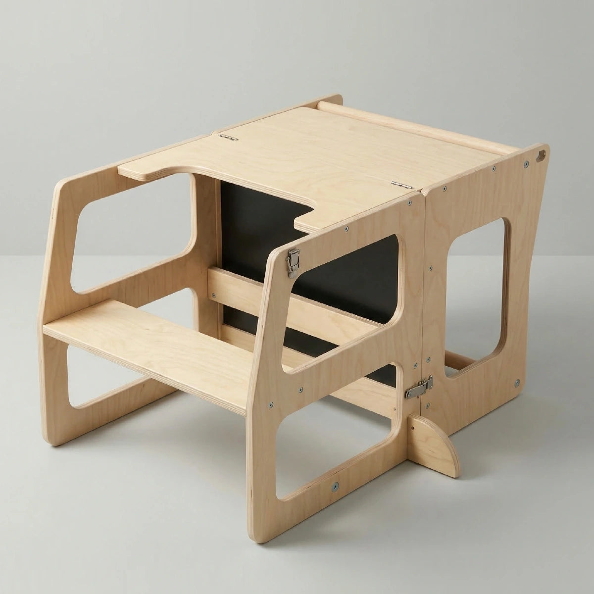 The Hicooo natural wood toddler tower folded down into a desk and chair configuration on a grey background, revealing a built-in black chalkboard on the back panel.