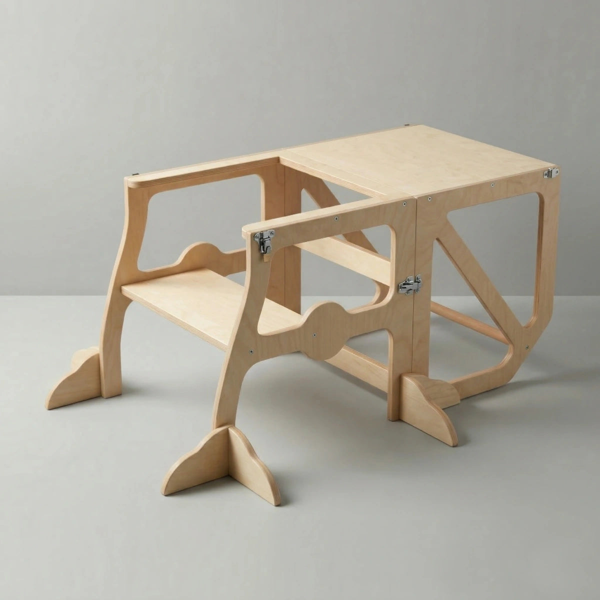 The Hicooo slim natural wood toddler tower folded down to reveal its secondary function as a play desk and bench seat, displayed against a light grey background.