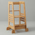 The Hicooo natural bamboo toddler learning tower shown from the front against a light grey background. It features a sturdy wide base, a lower step, an adjustable main platform, and wrap-around safety rails.
