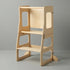 The Hicooo natural wood foldable toddler tower standing upright on a light grey background, showing its sturdy base, safety rails, and two step levels for young children.