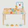 Studio product shot of hicooo wooden Montessori activity table. Features the table with attached sensory toys and displays the colorful geometric shape blocks (hexagon, circle, square, triangle) placed in front to highlight the shape sorting function.