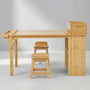 Front view studio shot of the Hicooo wooden art table set. Shows the full width of the desk featuring a paper roll holder on the left, a storage organizer on the right, and two matching stools placed underneath.
