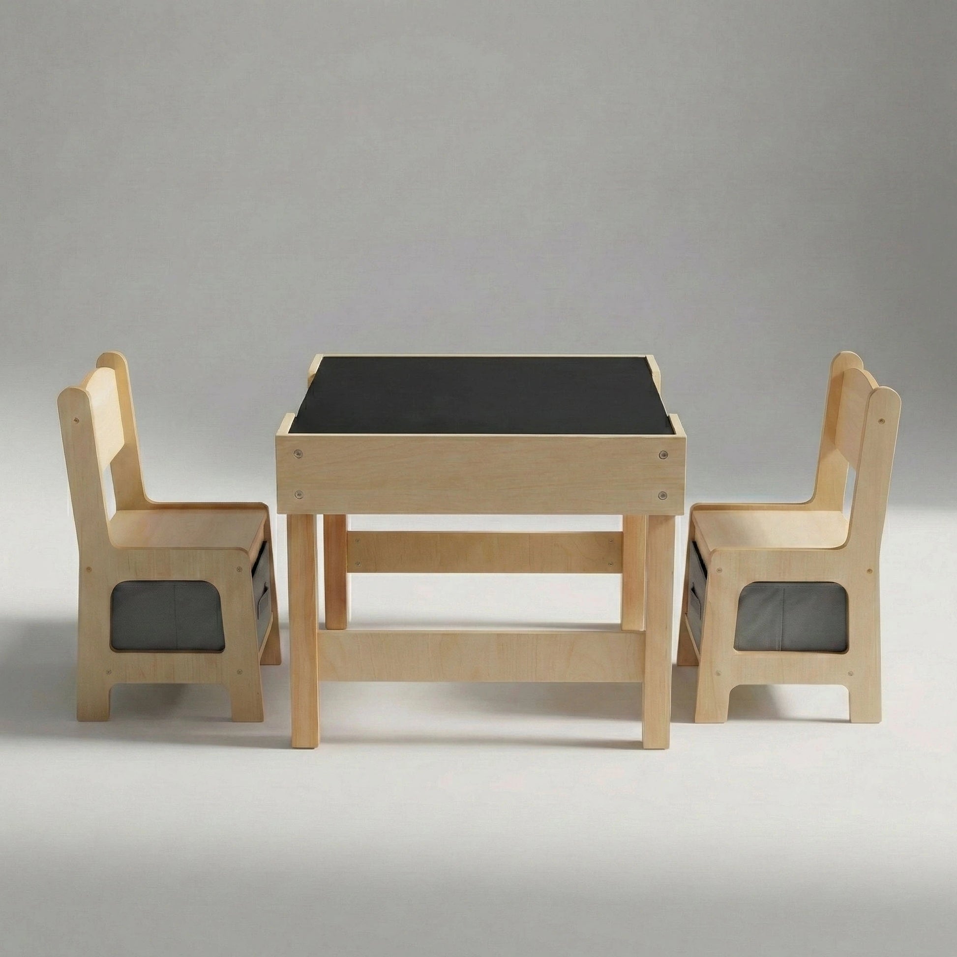 Studio shot of the Hicooo wooden kids' table and chair set showing the chalkboard surface for drawing. The matching chairs feature integrated grey fabric storage bins underneath the seats.