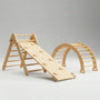 Studio product shot of a Hicooo Montessori wooden climbing set. Features a Pikler triangle connected to a ramp with climbing holds, alongside a separate climbing arch. All components are crafted from natural solid wood.