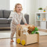 Happy child pushing a Hicooo wooden toy storage cart with yellow wheels, organizing plush toys in a modern living room.