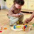 Mom and toddler playing colorful wooden train track set on hardwood floor