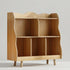 A solid wood kids bookshelf featuring a unique wavy edge design and multiple open storage compartments. This Hicooo Montessori-style organizer is perfect for a nursery or playroom.