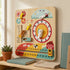 A lifestyle photograph of a kids' educational wooden calendar and clock board propped up on a wooden shelf in a softly lit room. It sits next to a small potted succulent and some books near a window, showcasing its interactive dials and colorful learning sliders.