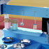 A close-up shot highlighting the realistic pretend play accessories of a light blue wooden kids mud kitchen. The foreground shows three shiny stainless steel toy pots and pans resting on simulated black stove burners. Above them on a blue wooden backboard, a stainless steel toy ladle and a slotted spatula hang from metal hooks. A narrow shelf holds two small pastel pink and blue jars with rustic textured lids. The bright lighting showcases the high-quality details of the cooking play set.