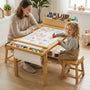 Lifestyle image of a mother and a toddler girl sitting on stools at the Hicooo wooden art table. They are drawing together on the continuous paper roll, showcasing the spacious tabletop and collaborative design suitable for parent-child bonding.