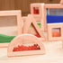 Triangular and rectangular wooden blocks filled with fine orange moving sand for sensory exploration.