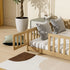 Wooden crib with striped mattress and decorative pillows in a room with a plant and table.