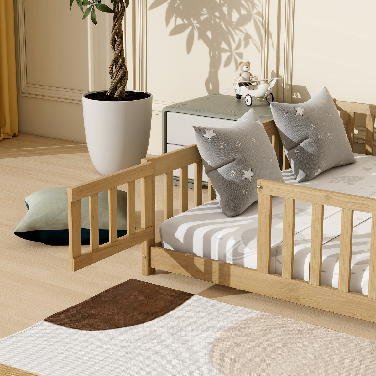 Wooden crib with striped mattress and decorative pillows in a room with a plant and table.