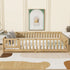 Wooden crib in a room with a rug and wall art