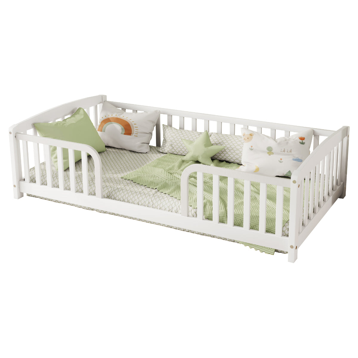 White wooden toddler bed with safety rails, styled with light green patterned bedding, matching pillows, and plush toys on a solid white background.