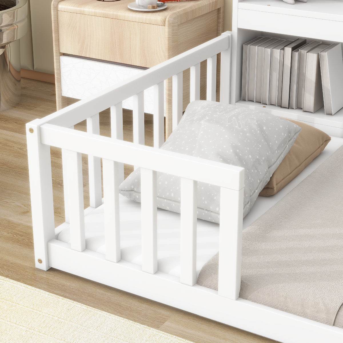 White crib with a pillow on a wooden floor in a room setting.