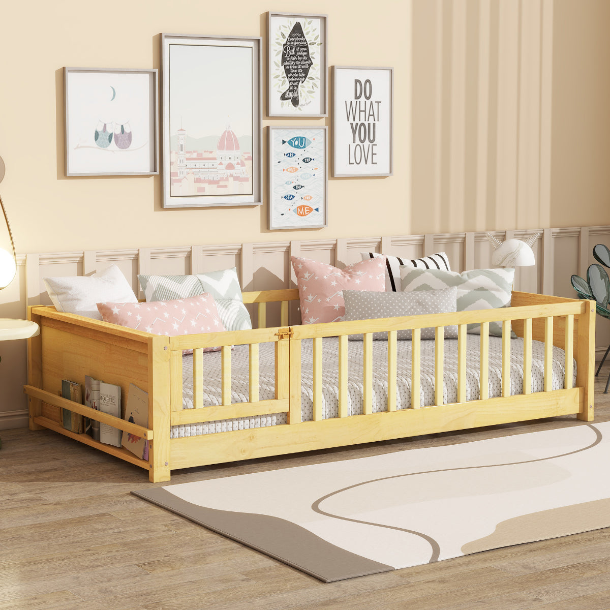 A light natural wood daybed with built-in safety rails, styled in a child's bedroom with pink and gray patterned pillows, framed wall art, and a neutral rug.