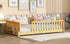 Children's bed with wooden frame and white bedding in a room setting.