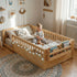 Lifestyle photography of the Hicooo wooden Montessori floor bed. Features safety guardrails, a built-in storage bookshelf at the footboard, and cozy LED string lights, showing a toddler happily playing on the mattress.