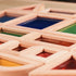Top-down angled view of various geometric sensory blocks arranged flat, showcasing different colored beads, sand, and liquids.