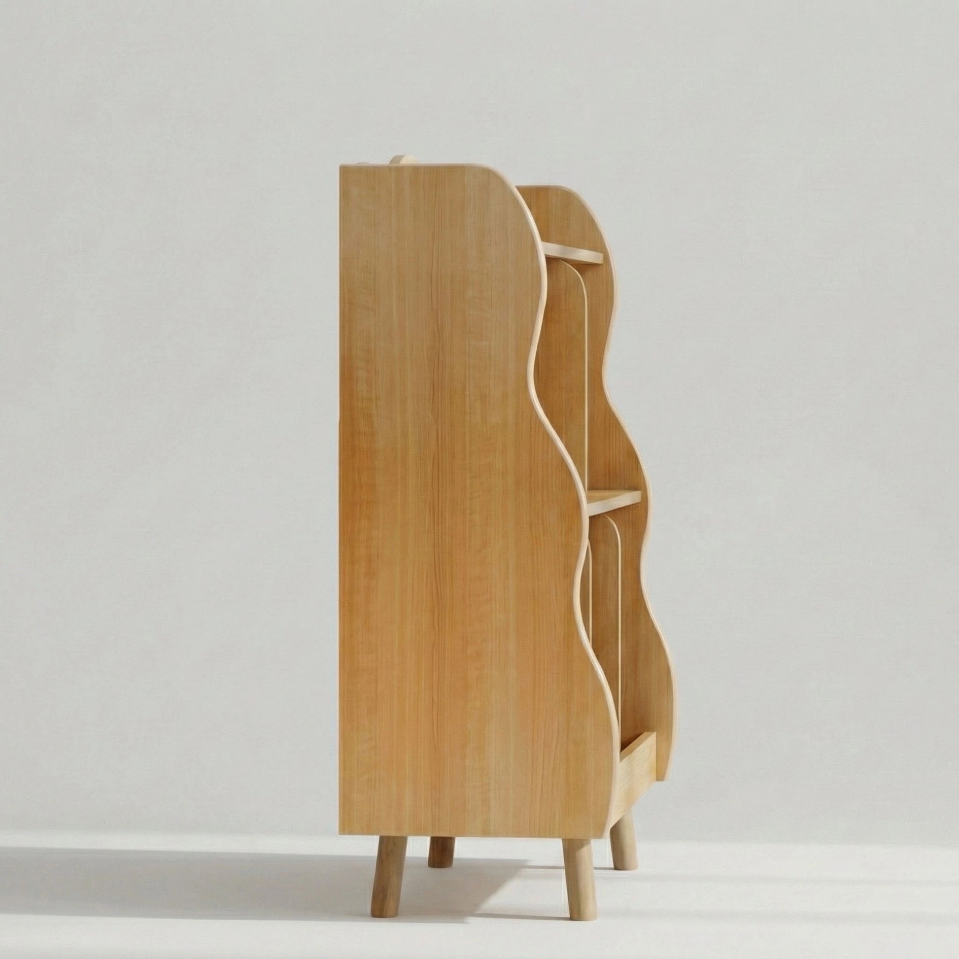 Side profile view of a wooden kids' bookshelf, showcasing its space-saving depth, wavy edge detailing, and sturdy raised legs.