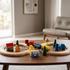 Wooden railway train set full layout on table in natural light with house and tree accessories