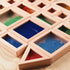 A semi-circle wooden sensory block filled with tiny red beads, showcasing texture and sound element.